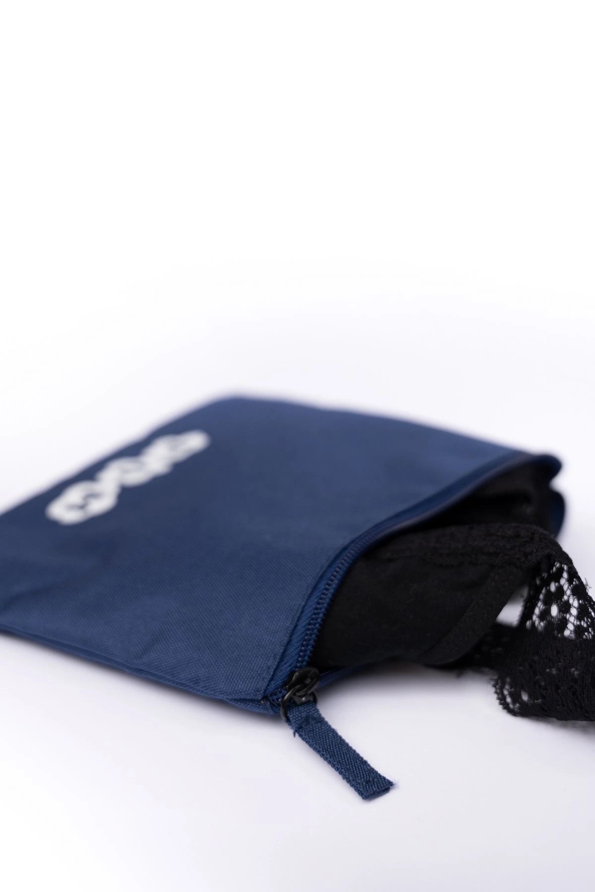 Close-up of the POM Waterproof Toiletry Bag’s zip detail, made from rPET (recycled plastic bottles), with a pair of POM period underwear partially visible inside.